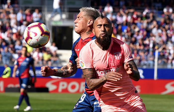 Vidal sufre la marca de un jugador del Huesca. Foto: EFE
